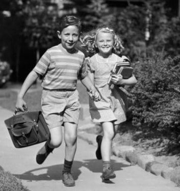 A black and white photo capturing the resiliency of two children as they engage in a playful game of running.