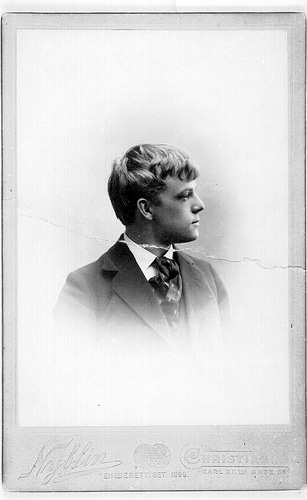 An old photograph capturing a young man in a suit, exuding an aura of Manvotional – embodying the spirit and potential of the Coming Man of the World.
