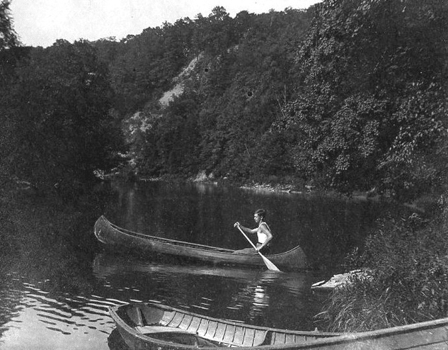 A man embarks on a canoe journey across a serene lake, marking a personal rite of passage.